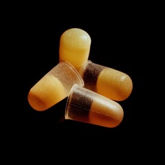 Three translucent capsules with a gradient of colors, set against a dark background, highlighting their unique shape and texture.