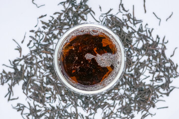 Top View of Freshly Brewed Black Tea with Loose Leaves on White Background