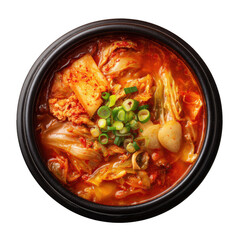 A hot bowl of spicy Korean kimchi stew topped with fresh green onions and garlic isolated on a black background