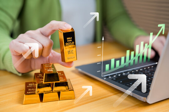 Investor holding gold bar with digital growth chart and upward arrows. Concept of gold investment, wealth accumulation, asset management, and long-term financial growth in global economy.