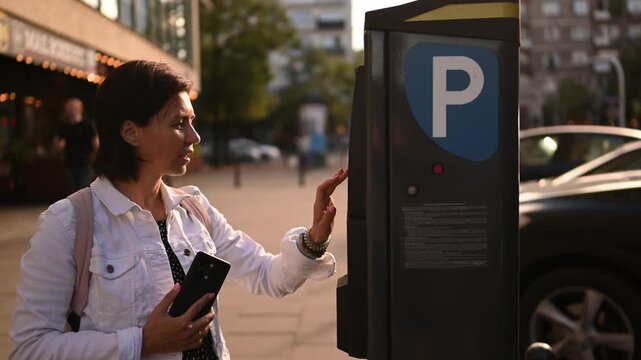 Woman Typing A Vehicle Plate Number On A Parking Meter Machine On A City Street