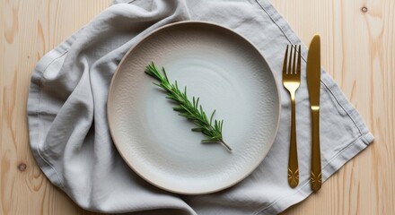 Elegant table setting with rosemary sprig on a plate golden cutlery and linen napkin perfect for restaurant menus and food blogs