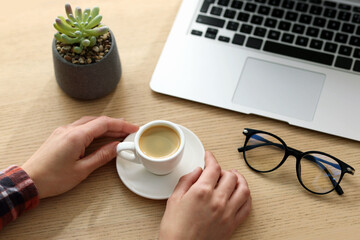 Woman having coffee break at wooden desk, closeup