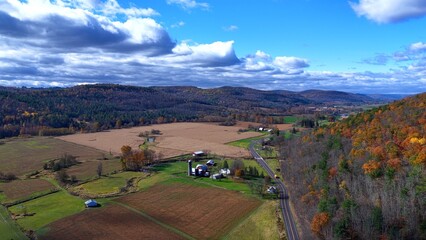 Pennsylvania countryside with rural farmland, green fields and mountains under sunny sky with clouds during Autumn  Fall season colors