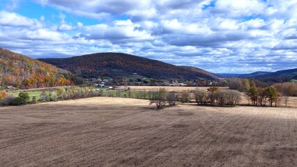 Pennsylvania countryside with rural farmland, green fields and mountains under sunny sky with clouds during Autumn  Fall season colors