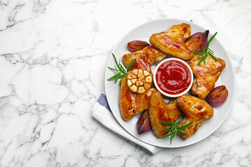 Delicious grilled chicken wings served on white marble table, top view. Space for text