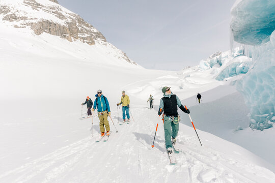 A group of skiers explore the large ice caves in the Northern Rockies of British Columbia, Canada.