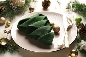 Festive table setting with Christmas decor on beige background, closeup