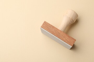 One wooden stamp on beige background, top view. Space for text