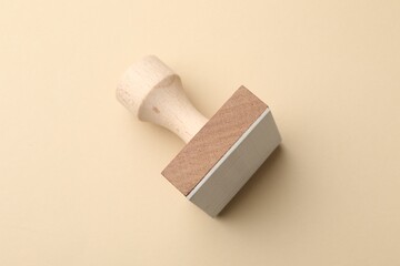 One wooden stamp on beige background, top view
