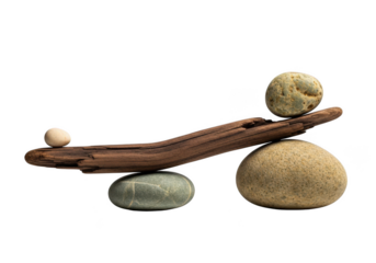 Weathered driftwood and polished river stones carefully balanced together forming a conceptual scales composition.