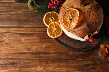 Christmas food. Delicious Panettone cake, ingredients and festive decor on wooden table, flat lay. Space for text
