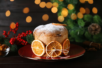 Christmas food. Delicious Panettone cake, ingredients and festive decor on wooden table against...