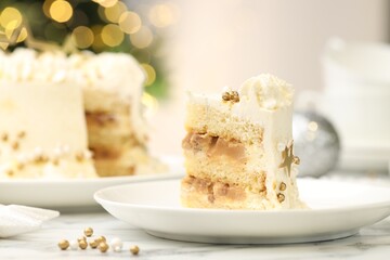 Piece of delicious cake with Christmas decor on white marble table, closeup
