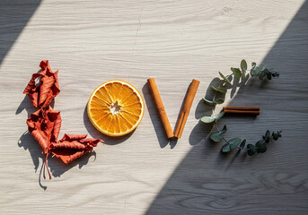 LOVE Spelled with Natural Elements on Sunlit Wooden Surface