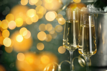 Sparkling wine in glasses, bokeh lights. New Year greeting card