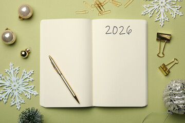 New 2026 Year Goals. Inscription in notebook on table with festive stuff, top view