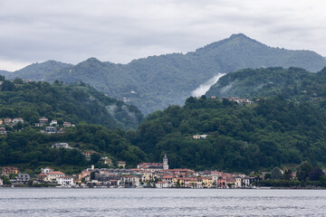 Scenic panorama of Lake Orta with village of Orta San Giulio, layers of forested mountains and...