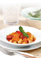 Chickpeas with bacon and spicy chorizo, garnished with chili pepper and fresh mint