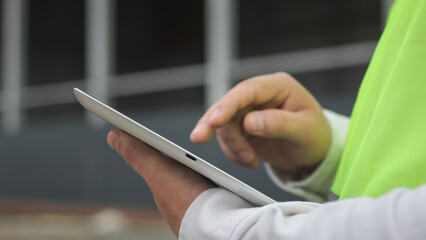 Electronic tablet. Human hand. Construction site.High quality photo