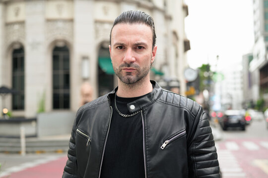 Fototapeta Handsome bearded man in black leather jacket posing in city streets