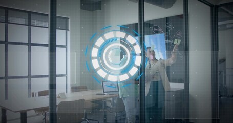 Business professionals affixing notes and interacting with digital interface on glass in office