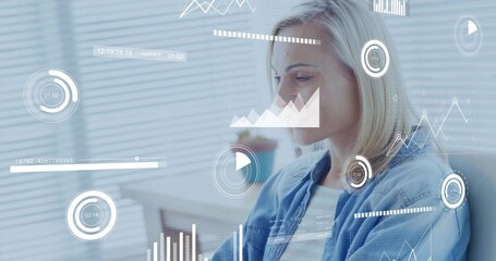 Mid adult woman analyzing floating data charts at office desk, with blinds and plant, copy space
