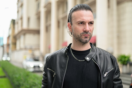 Fototapeta Handsome bearded man in black leather jacket posing in city streets