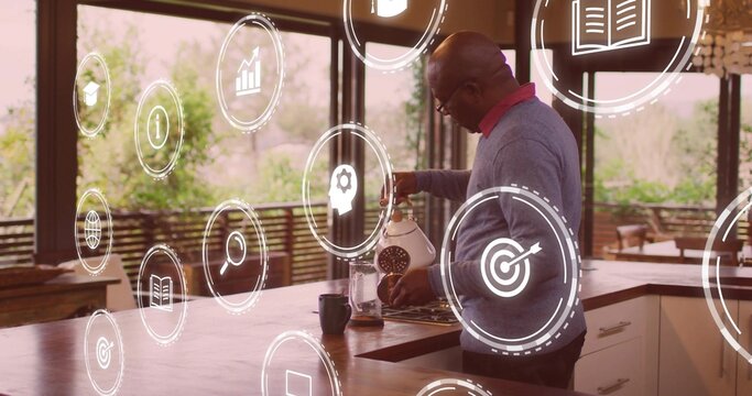 Man in sweater pouring water from kettle into coffeemaker in kitchen, with icons, copy space - Powered by Adobe