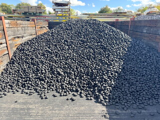 A large pile of coal is stored in a bay ready for distribution to customers