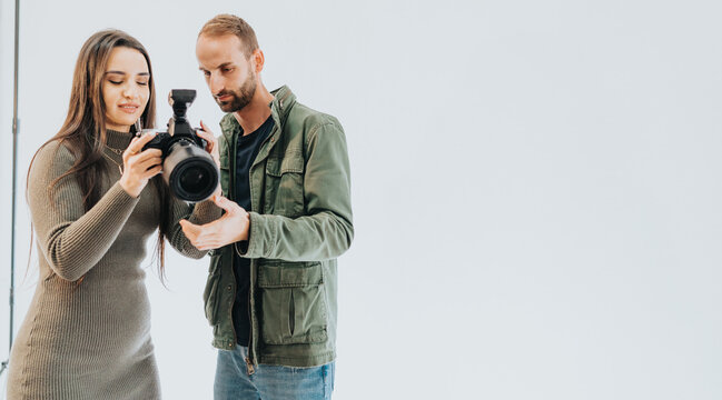 Two people observing a camera together, sharing insights and learning about its functionality in a bright environment.