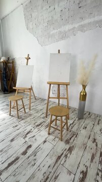 This bright art studio features a large table, a comfy chair, and colorful artwork, fostering creativity