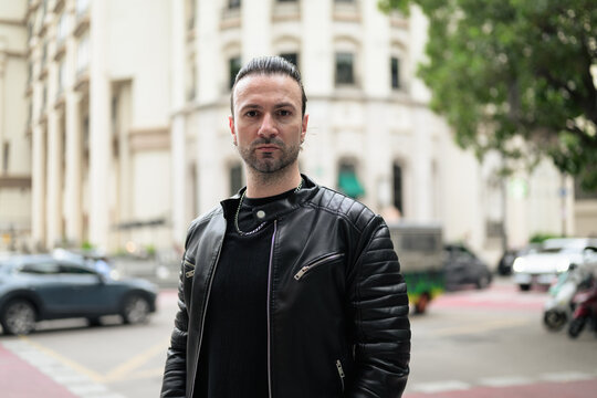 Fototapeta Handsome bearded man in black leather jacket posing in city streets