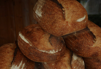 Rustic sourdough bread loaves stacked, showing artisan baking, fresh crust, and traditional bakery food
