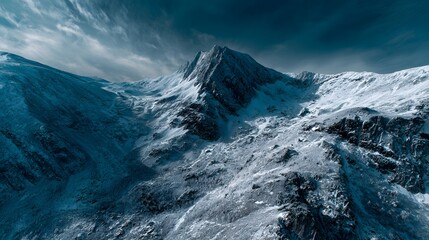 Jagged mountain peak covered in snow dominates a dramatic, cold landscape under a dark sky