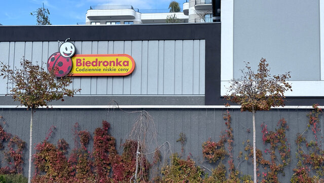 Warsaw, Poland - October 04, 2025: Biedronka supermarket sign on modern building with greenery around
