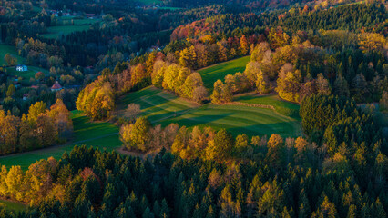 Herbstliche Landschaft mit bunten Bl&auml;ttern und sanften H&uuml;geln in der Abendsonne