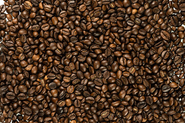 Close-up view of roasted coffee beans filling the frame, showcasing rich brown hues, glossy textures, and natural variation in tone, symbolizing aroma and freshness.
