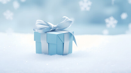 Beautiful blue gift box with a ribbon sits on fresh snow in a winter landscape