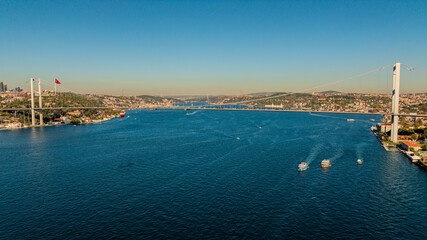 Aerial view of the Bosphorus Bridge with drone on a cloudy day. Tanker ship passing under the FSM Bridge with a heavy car traffic on the bridge.Aerial view of The Second Bosphorus Bridge.
