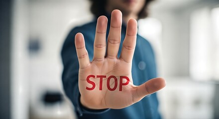 Hand held up with the word STOP displayed, signaling a clear and urgent message to halt or pause any action immediately, conveying authority and control.