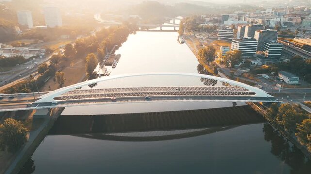 Experience the calm beauty of the Vltava River as the morning sun illuminates Troja Bridge. A serene moment in Prague, where nature meets modern architecture.