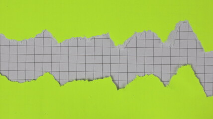 Yellow paper torn in two pieces with a checkered background for copy space.