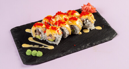 Gourmet salmon sushi rolls served on a black plate with garnishes, ready for a fine dining experience