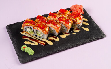 Gourmet salmon sushi rolls served on a black plate with garnishes, ready for a fine dining experience