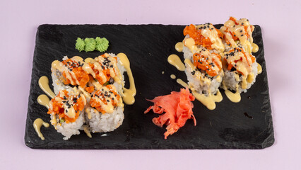 Gourmet salmon sushi rolls served on a black plate with garnishes, ready for a fine dining experience