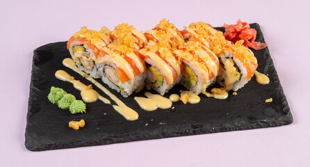 Gourmet salmon sushi rolls served on a black plate with garnishes, ready for a fine dining experience