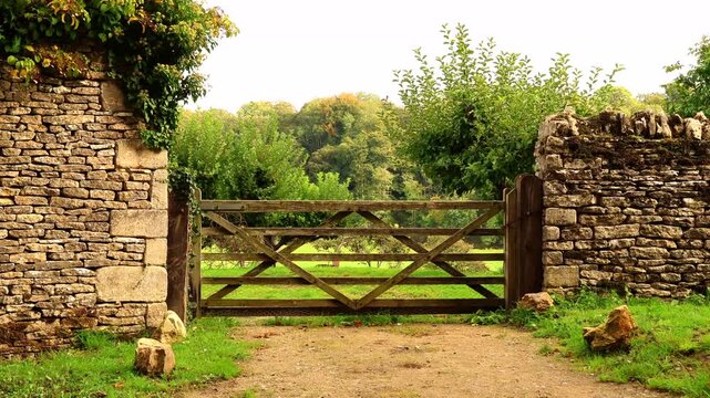 Wooden country gate in the rural English Cotswolds. Cotswolds countryside, England