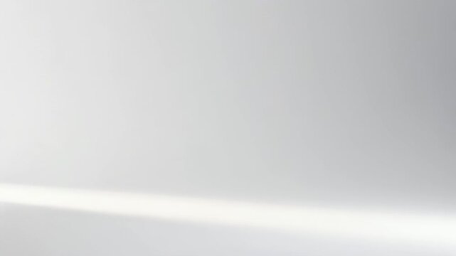 A soft grey studio background with a gentle, bright horizontal light streak across the bottom