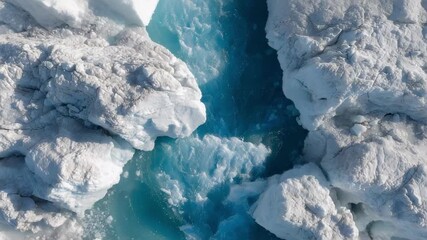 A glacier crevasse with bright blue ice and turquoise meltwater pooling between jagged ice blocks. - Powered by Adobe